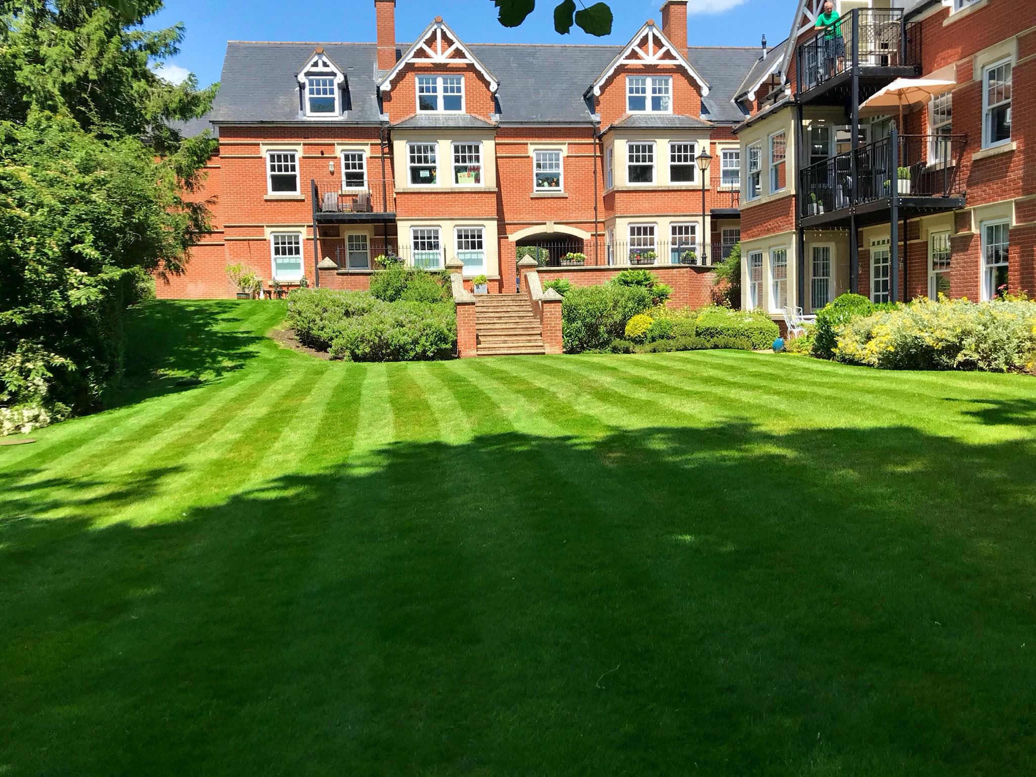 Westlecot House Beautiful healthy green lawn with red brick house sun shining blue sky